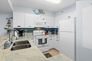Fully stocked kitchen with dishes, utensils, pots and pans, blender and all the odds and ends