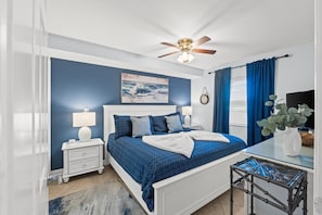 Primary bedroom with comfortable king bed, smart TV and black out curtains