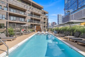 Communal Area: Sparkling blue pool with covered cabanas, sun loungers, and a wheelchair lift.