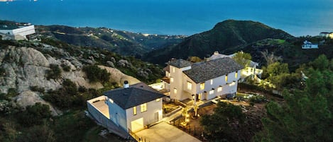 Stunning dusk view of The Malibu Cloud House with ocean and mountain vistas.