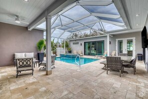 Luxuriate in our courtyard's heated pool and spa area, complete with lounge chairs, a large TV, dining table, and a cozy sitting area