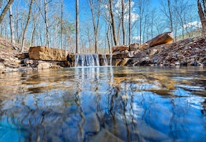 A scenic stream winds its way through the property, adding to the natural beauty and peaceful atmosphere.