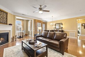 Open space living area with new leather sofa, gas fireplace, and smart Roku TV