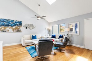 Living room with vaulted ceiling and skylights
