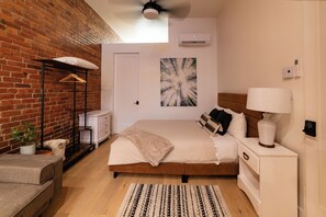 Comfortable queen size bed near door to the bathroom.