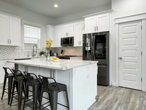 Fully-equipped kitchen with granite countertops and bar seating.