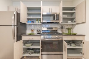 Fully stocked kitchen: stainless steel appliances, pots, cutting board & more