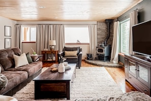 Cozy living room, natural sunlight with gorgeous views of the surrounding trees