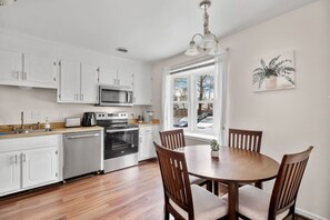 We have a fully equipped kitchen featuring a microwave, dishwasher, stove, oven, Keurig coffee maker, and more. It's conveniently adjacent to the dining area, which comfortably seats four people.