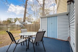 Step into the outdoor patio offering seating for four, where you can unwind and enjoy the tranquility of your private backyard retreat.