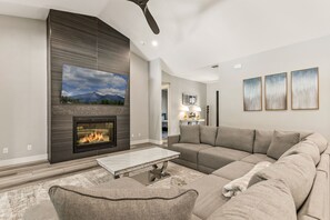 An expansive living area with fireplace and large screen television