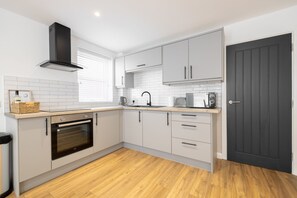 Kitchen with microwave, oven, hob and necessary equipment  