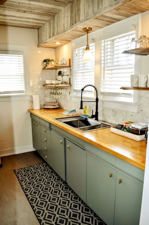 Serene new kitchen w/ marble back splash & whitewashed reclaimed cedar ceilings.