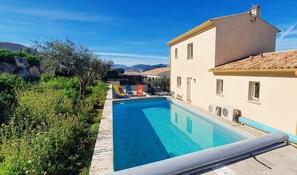 Piscine à l'arrière de la maison, avec espaces détente et repas