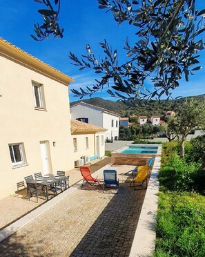 Piscine à l'arrière de la maison, avec espaces détente et repas