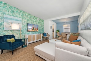 After a sunny day at the beach, unwind in the cozy living room, perfect for a game night or streaming your favorite movies and shows on the 55" Smart TV.