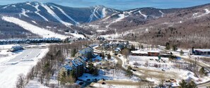 Drone shot of Mountain Green Resort in the winter with Killington Mountain in the background.