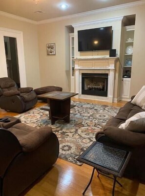 Living room with comfortable sofa, 55" flat screen (Netflix) and fire place.