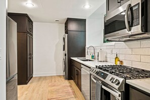 Cook, dine, and live with ease in the Courtyard Suite's full kitchen, boasting sleek appliances and a convenient washer/dryer combo. It's the perfect fusion of functionality and style for both short and extended stays in Sturgeon Bay.
