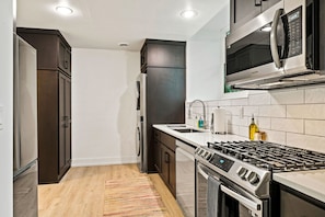 Cook, dine, and live with ease in the Courtyard Suite's full kitchen, boasting sleek appliances and a convenient washer/dryer combo. It's the perfect fusion of functionality and style for both short and extended stays in Sturgeon Bay.