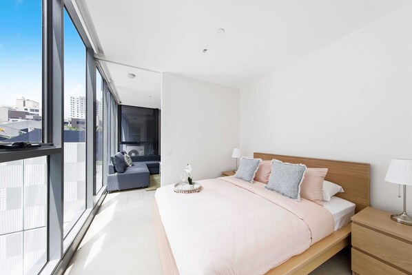 A bedroom with a queen sized bed & plush pillows