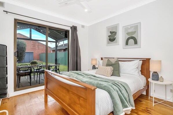 The second bedroom includes a queen bed and direct access to the backyard, while both bedrooms offer ceiling fans. 
