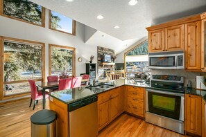 Tranquility on the River Three - The kitchen is open to the dining area and living area with a full size refrigerator, oven and microwave