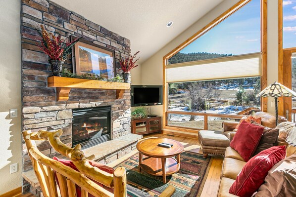 Tranquility on the River Three #3 -- 20-NCD0365 - a SkyRun RMNP Property - Tranquility on the River Three - Large open living with plenty of comfy seating for all, floor to ceiling windows with a river view, and cozy gas fireplace.