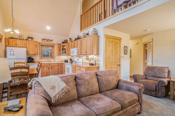 Solitude Raven #5 - Estes Park - a SkyRun RMNP Property - Solitude Raven 5 - Living room adjacent to the kitchen, with sofa that seats 3, arm chair, and kitchen.