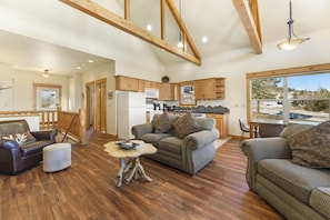 Main level living area with two double-cushion sofas, a loveseat, and vaulted ceilings. Beautiful mountain views from large floor to ceiling windows.