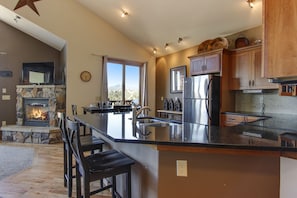 The Twin Owls 21A - The well equipped kitchen looks out into the living room with fireplace and flat screen TV 