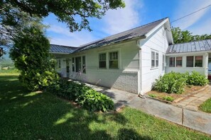 Front of the house. You'll use the side door under the carport.