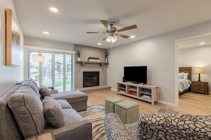 Living room with queen sleeper sectional seating, smart TV, and electric fireplace