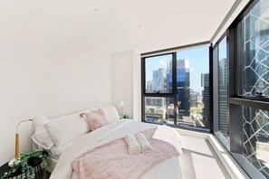 The master bedroom with a queen sized bed & city views.