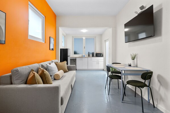 Functional living room with a couch, chairs, coffee table, and a flat-screen TV, ideal for unwinding after a day of exploring.