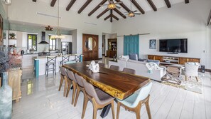 The open concept kitchen, living and dining space features modern appliances and a locally sourced Guanacaste wood table for 10.  