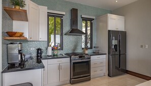 The open concept kitchen has a gas stove, large fridge and dishwasher.