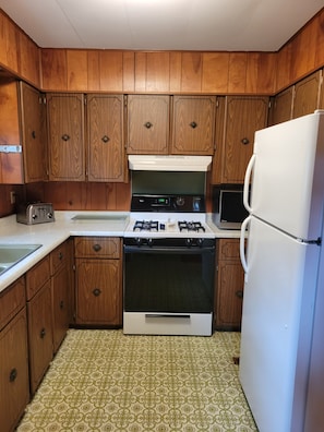 Kitchen with stove, refrig, and microwave