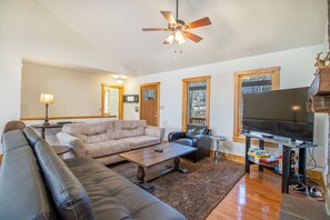 Living area includes lounge seating, television, and fireplace