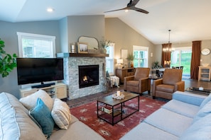 Upstairs living room with views of greenery out of the front windows. 