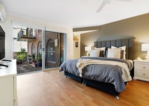 The generous first bedroom features a king-size bed and a TV, with direct access to the entry courtyard. 
