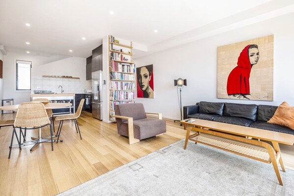 Enjoy kicking back in this retro-cool living room featuring a Hollywood feature light, striking portrait art and an impressive home library collection.
