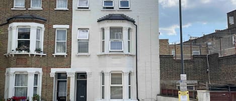 Exterior of the home - A beautifully maintained three-story end-of-terrace home with a fresh white facade, offering a perfect blend of character and modern comfort