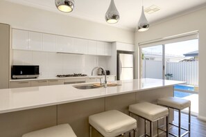 The sleek kitchen is designed around a central island, perfect for preparing meals at home.
