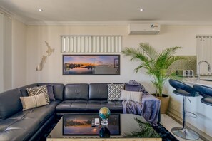 Unwind in the inviting living room, adorned with a touch of tropical inspiration, where comfort meets style. Sink into the plush seating, bask in the warm ambiance, and create lasting memories in this cosy retreat.