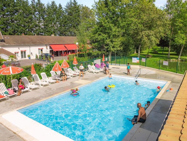  A sparkling pool nestled in lush greenery invites guests to cool off and unwind in a serene, inviting environment.