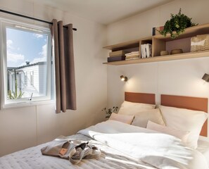 Drift into relaxation in this serene bedroom, complete with cozy linens and a window view that brings in gentle morning light.