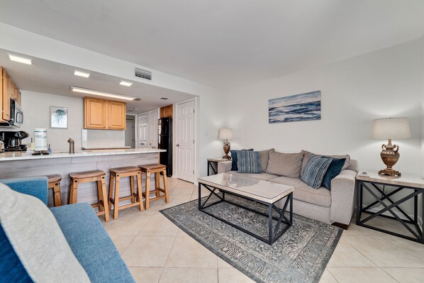 Prepare meals in the kitchen while staying connected with loved ones relaxing in the cozy living area.