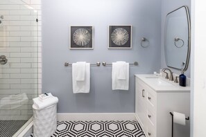 Treat yourself in this luxuriously modern bathroom outfitted with soft, white towels and start up bathroom amenities.