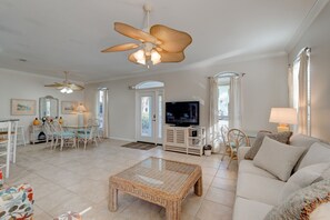 In the corner of the living room there is an additional table and chairs set up for four.